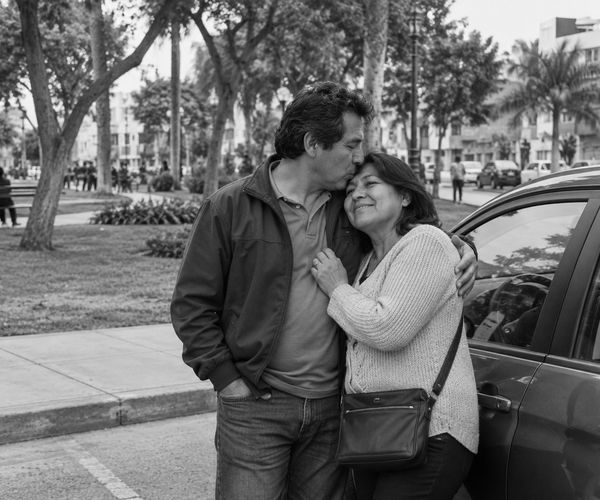 Pareja abrazada junto a su auto