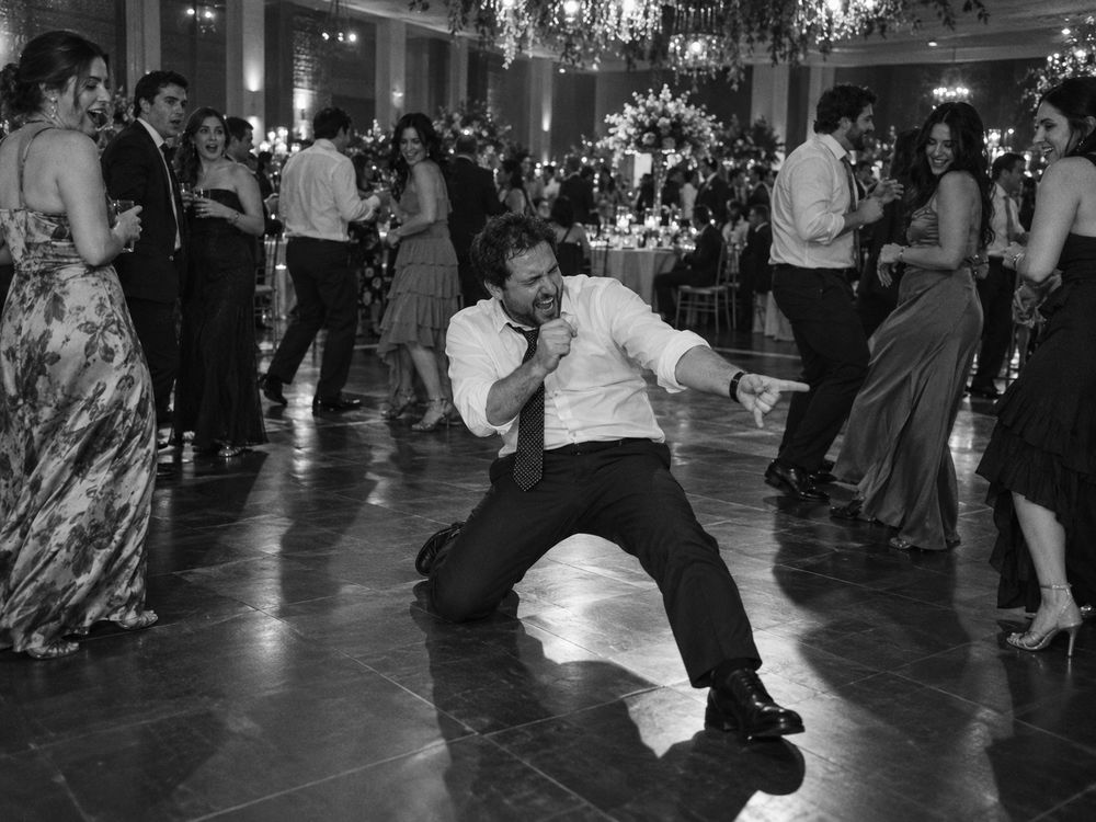 Un hombre de unos 38 años canta con entusiasmo en la pista de baile de un matrimonio.